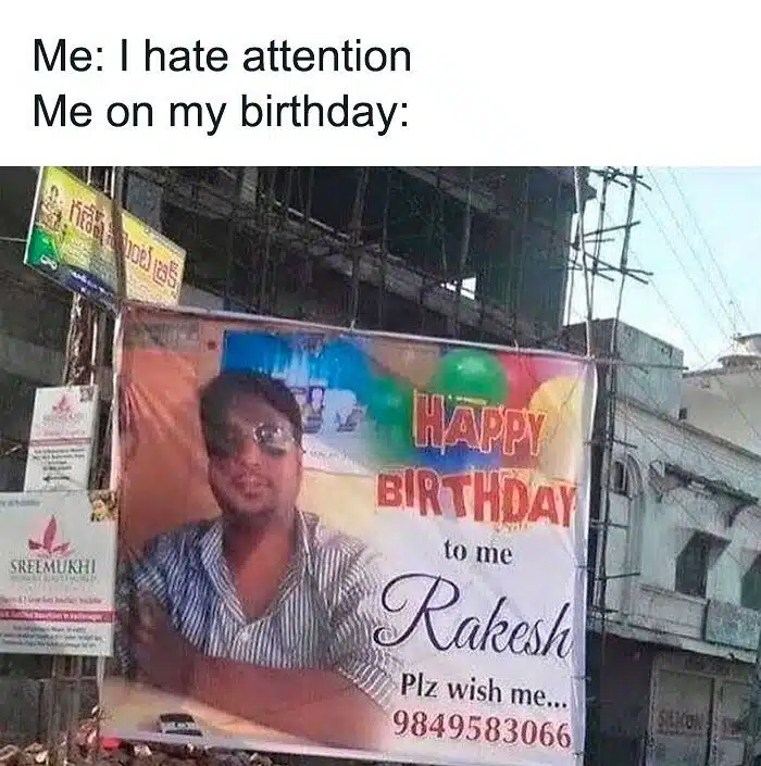 A birthday meme showing a large outdoor birthday banner with a photo of a man named Rakesh, and the text "Happy Birthday to me Rakesh. Plz wish me 9849583066." The caption reads, "Me: I hate attention. Me on my birthday:" Perfect for friends who claim to dislike attention but secretly enjoy it on their special day.