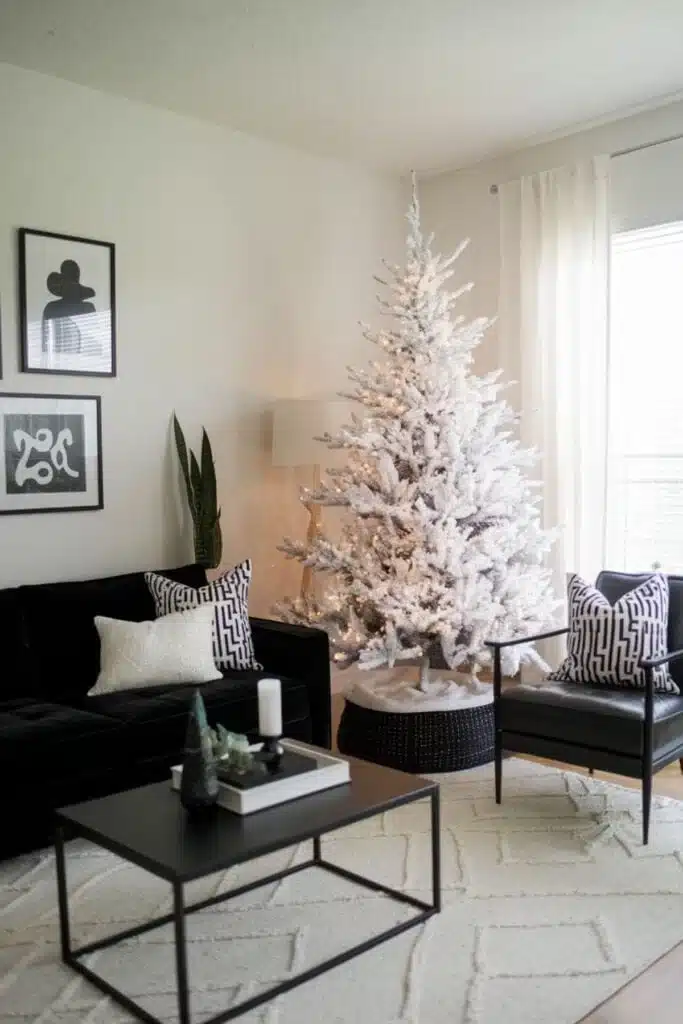 
A modern living room for Christmas with a black couch and a white tree