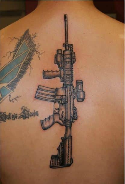 Gun Tattoo Idea on spine for men