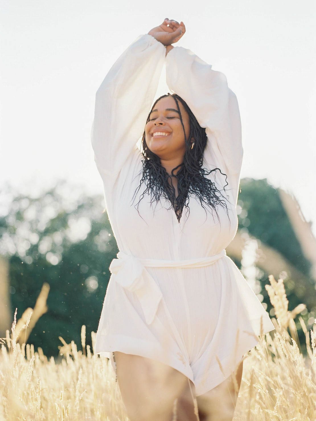 A photo of an hourglass shaped black woman smiling