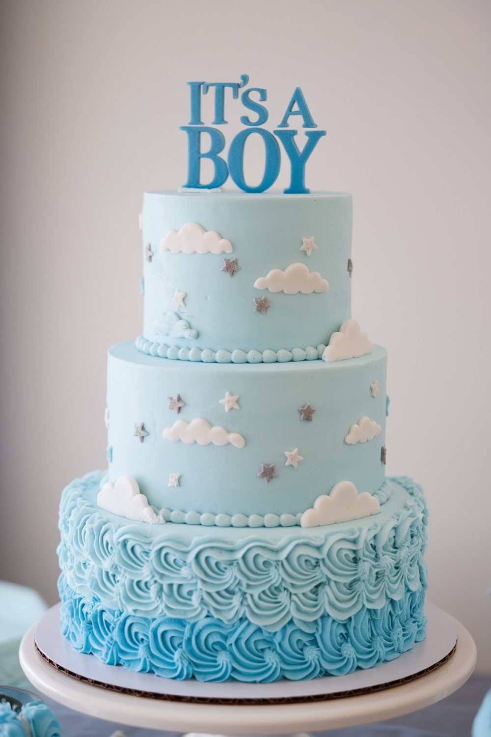 Baby Boy Gender Reveal Cake – Light blue cake with cloud and star decorations for a baby shower.
