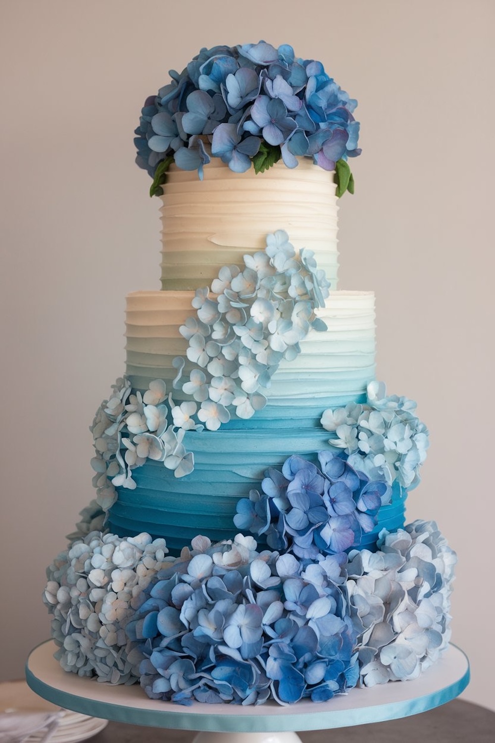 Hydrangea Bliss Cake – A floral cake decorated with blue hydrangeas cascading down the tiers.
