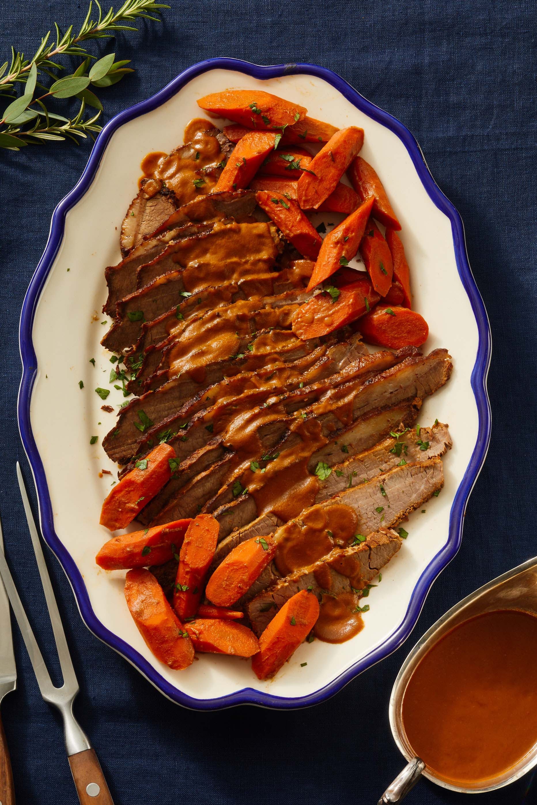 sliced braised brisket on a white platter with blue border