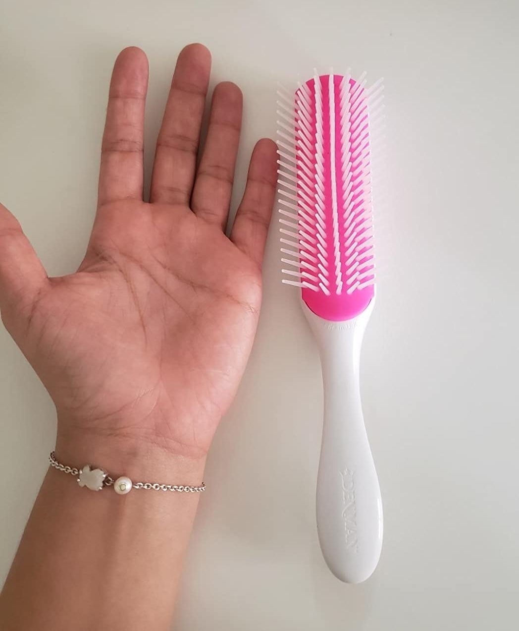 Reviewer hand next to white brush on table