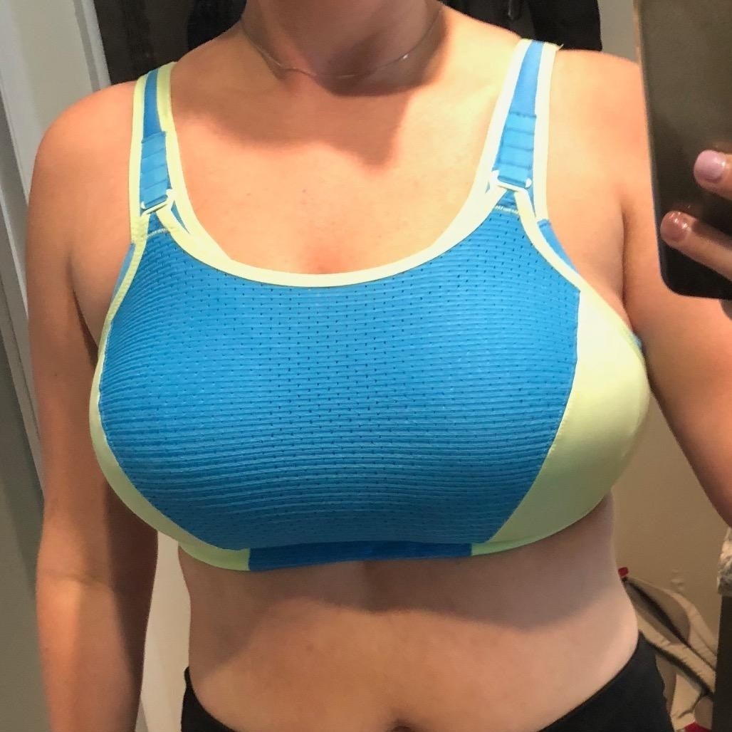 A reviewer wearing a blue and lime green bra with black leggings