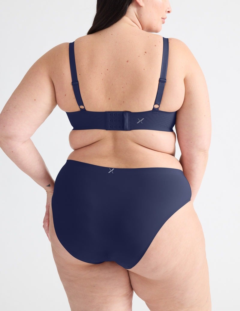 Person modeling a seamless bra and underwear set, emphasizing comfort and fit. Suitable for shopping context