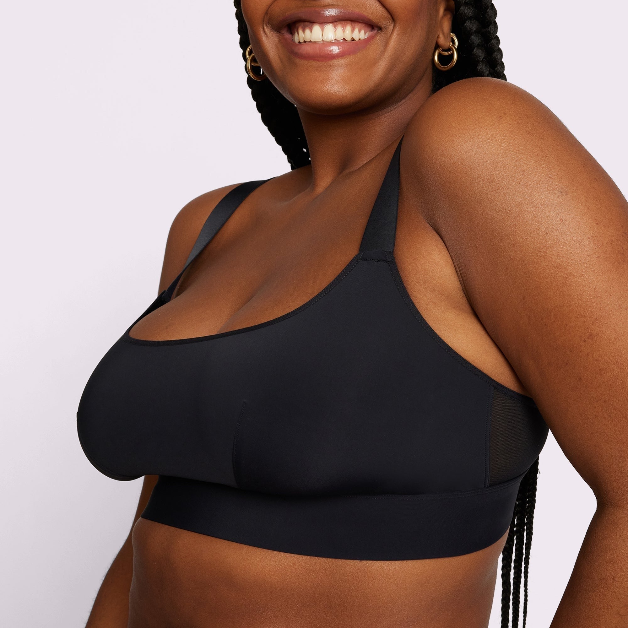 Woman smiling, wearing a sleek, supportive sports bra