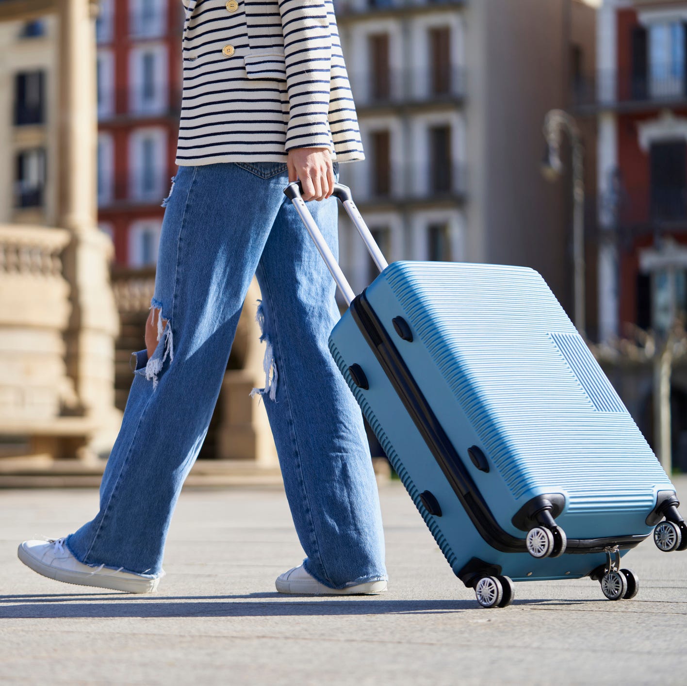 close up of a woman with a trolley on the street on the way to the hotel