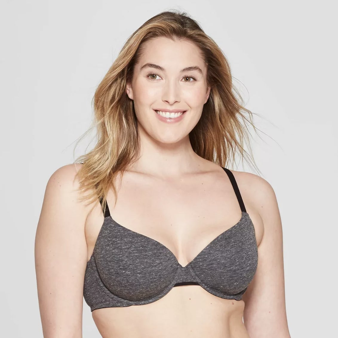 model smiling in a gray bra