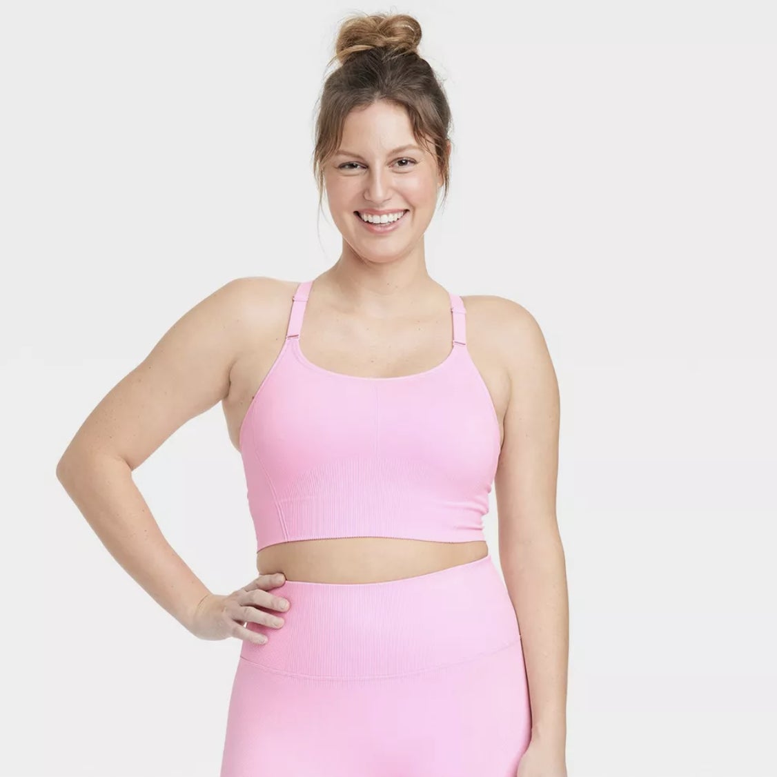 model posing in a matching pink sports bra and leggings set