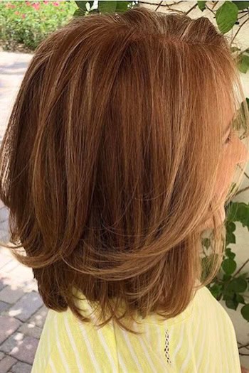 Long Bob with Subtle Layers Hairstyle on an older woman with layered shoulder-length brown hair, side view.