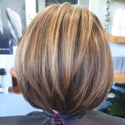 Rounded Bob With Volume Hairstyle on a woman with layered brown hair, back view.