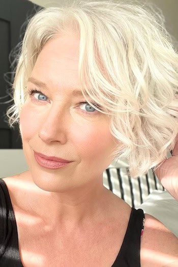 Short Wavy Bob With Texture Hairstyle on an older woman with layered bright light blonde hair.