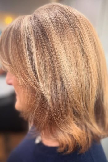 Layered Lob With Wispy Layers Hairstyle on an older woman with layered brown hair, side view.