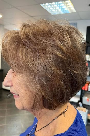 Layered Bob with Volume hairstyle on a woman in her 60s with brown hair, side view.