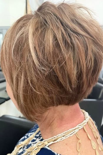 Voluminous Layered Bob With Texture Hairstyle on an older woman with layered brown hair side/back view.