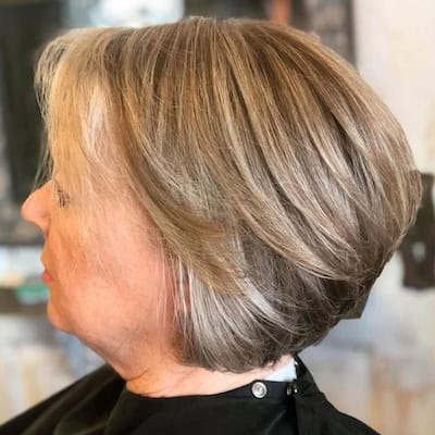 Stacked Bob With Layers Hairstyle on an older woman with layered brown hair, side view.