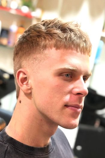 Textured Edgar Cut with Fade Men's Haircut, side view.