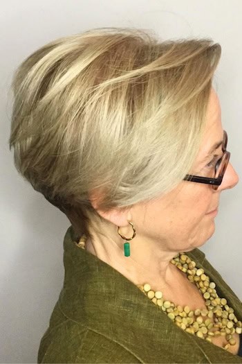 Short-Tapered Pixie Bob hairstyle on a woman in her 60s with blonde hair, side view.