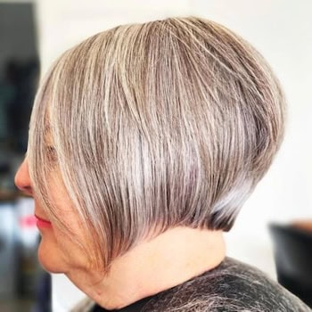 Angled Bob with Subtle Layers hairstyle on a woman in her 60s with silver hair, side view.