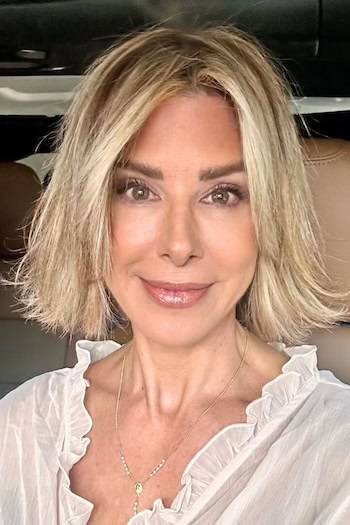 Wispy Chin-Length Bob Hairstyle on a smiling older woman with blonde hair.