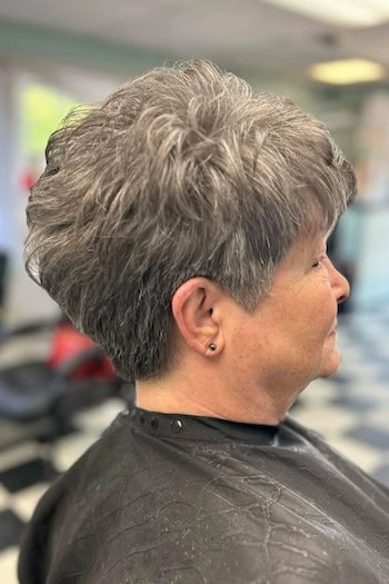 Classic Short Pixie hairstyle on a woman in her 60s with gray hair, side view.