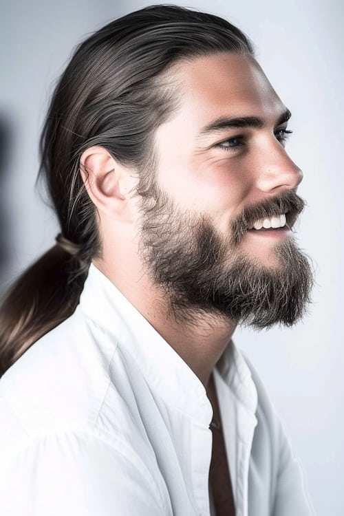 Polish low ponytail with beard on attractive man, side view.
