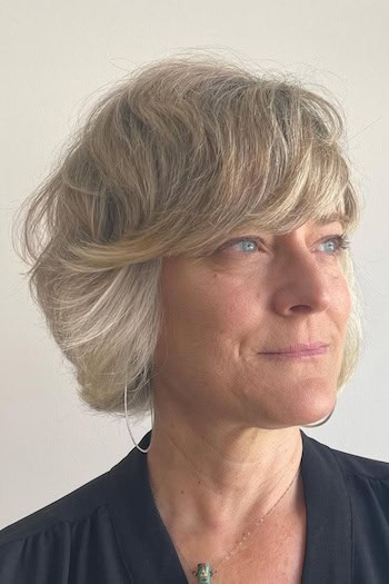 Textured Layered Bob hairstyle on a woman in her 60s with blonde hair.