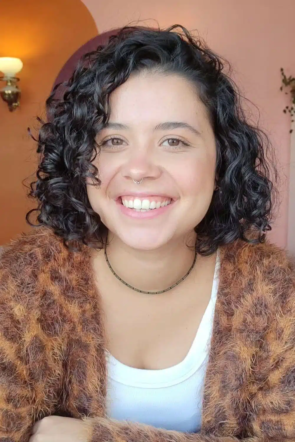 A woman with a black blunt curly bob cut.