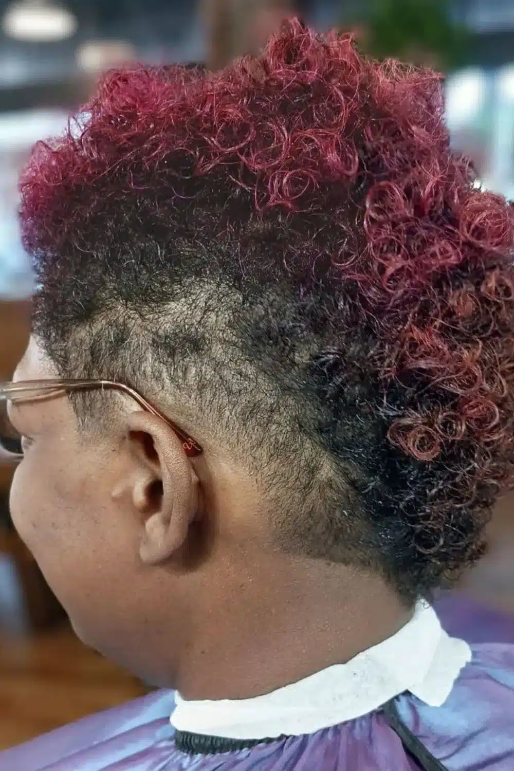 A woman with a red curly faux hawk.
