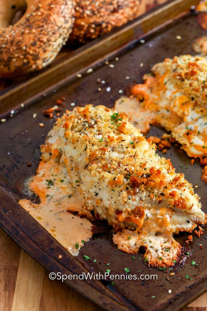 This stuffed chicken recipe is filled with a cream cheese mixture, breaded in bagel crumbs and topped with everything bagel seasoning before being baked. It is a delicious meal that is full of flavor! #spendwithpennies #stuffedchicken #everythingchicken #maincourse #chickenrecipe #breadedchicken Everything Cheese Stuffed Chicken on a baking sheet