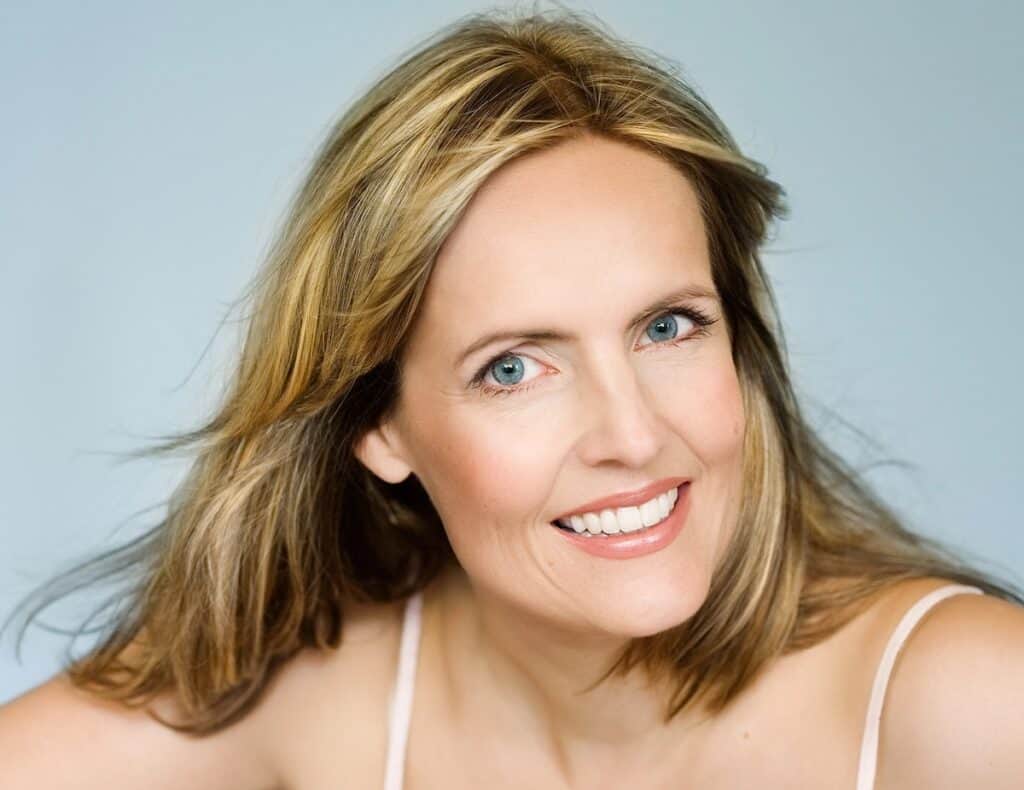 Woman with shiny shoulder length hair wearing a tank top.