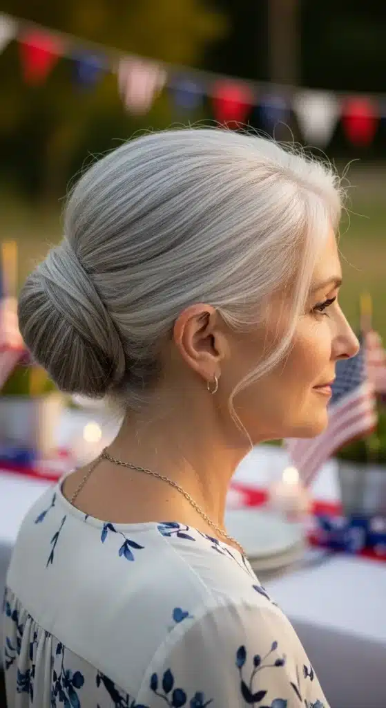Tucked French twist hairstyle for women over 60 styled for 4th of July 2025, featuring soft silver hair in a low elegant twist with a relaxed festive summer backdrop.